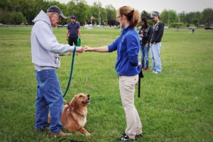 Emily training owner and his dog Stephanie for obedience training outdoors